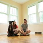 a person and a dog sitting on the floor in a room
