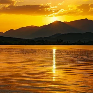 a vibrant sunset casts golden hues over a tranquil lake, with silhouetted mountains framing the horizon, creating a serene and picturesque landscape.