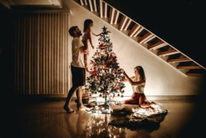 a group of people standing around a christmas tree