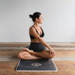 a woman sitting on a yoga mat