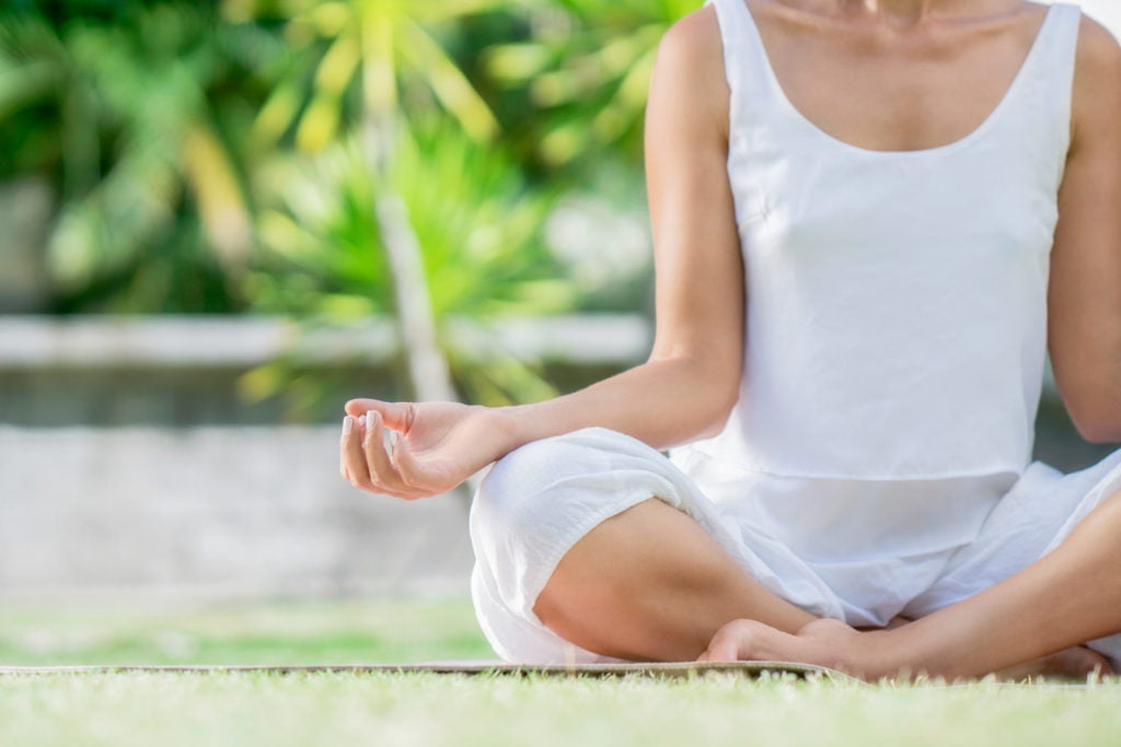 a woman meditating on the ground